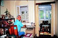 Inside their old Panchgani house on a Table Land shelf, with its typical window panes and old floral tiling, Russo sits at his desk in work.