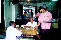 A waiter serving early morning diners at Paragon.